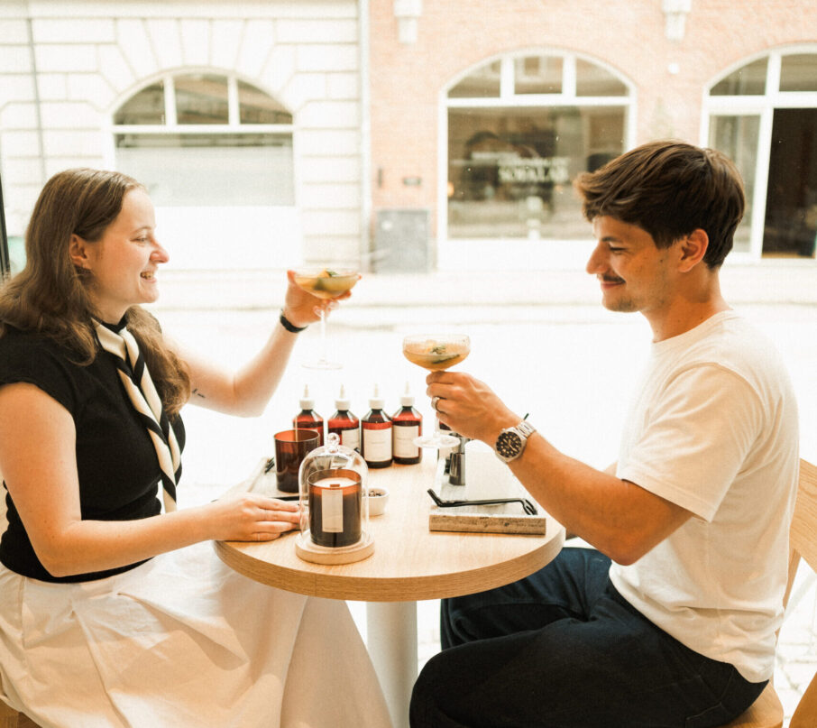 Par sidder og nyder en mocktail og laver duftlys